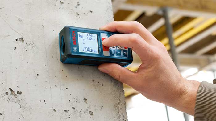 Bosch laser tool checking the distance between two walls
