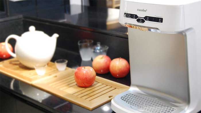 mini countertop water cooler next to apples