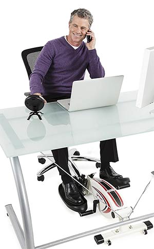 Office worker using an under desk elliptical