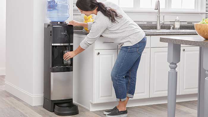 woman filling a cup at a water dispenser