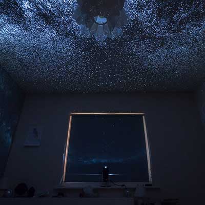 stars projected on a white ceiling next to a window