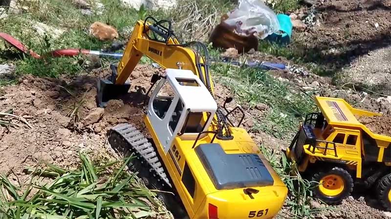 RC Excavator toy digging into soil