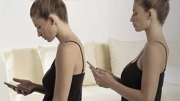 Woman getting a reminder for slouching on her smartphone then correcting her stand